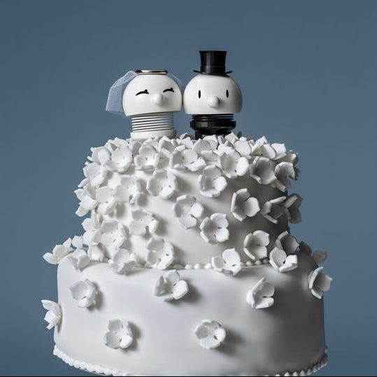 Hoptimist Braut und Bräutigam nebeneinander auf einer Hochzeitstorte
