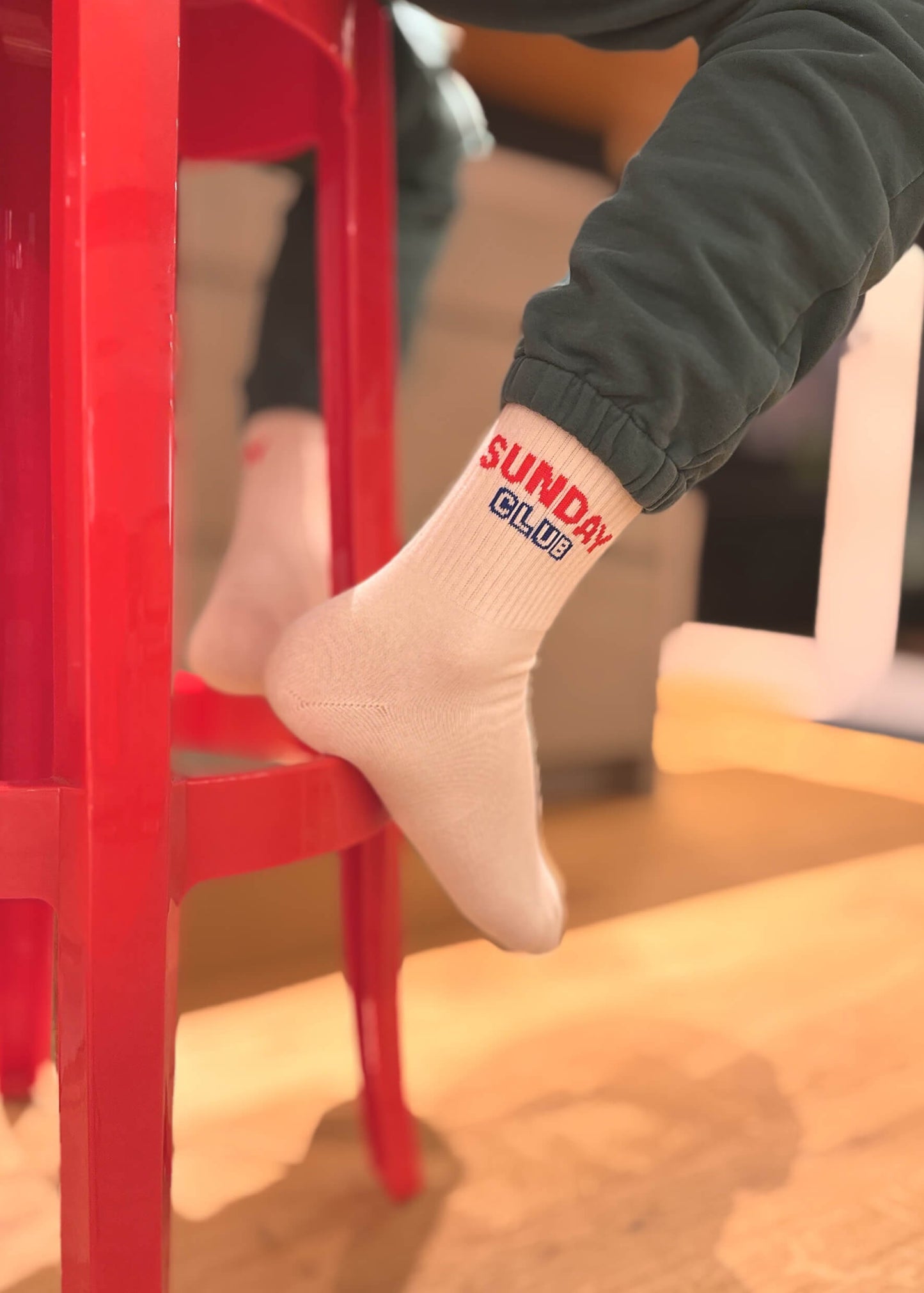 Lifestyle-Bild mit „Sunday Club“ Socken an erwachsenen Füßen