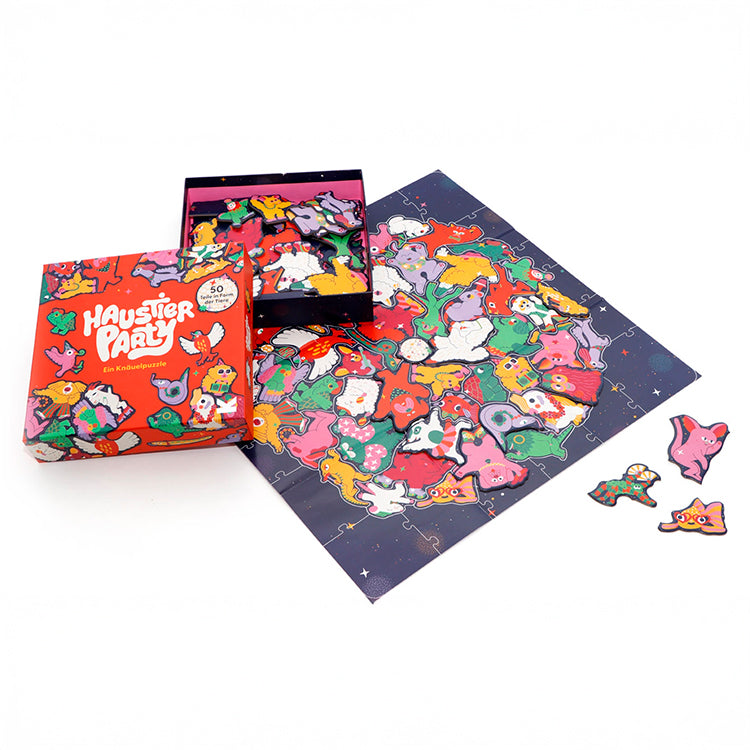 Offene Puzzle-Schachtel mit Haustierparty-Puzzle und beiliegendem Poster, das das fertig zusammengesetzte, bunte Party-Motiv zeigt.
