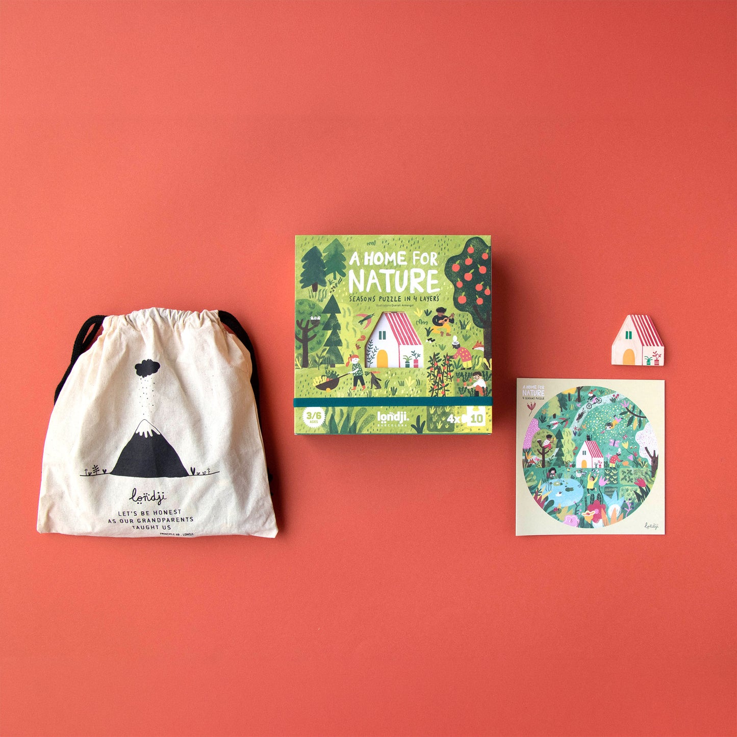 Ausgepacktes Spiel „A Home for Nature“ von Londji mit Box, Aufbewahrungssäckchen, Referenzbild und dem kleinen ausgestanzten Holzhaus