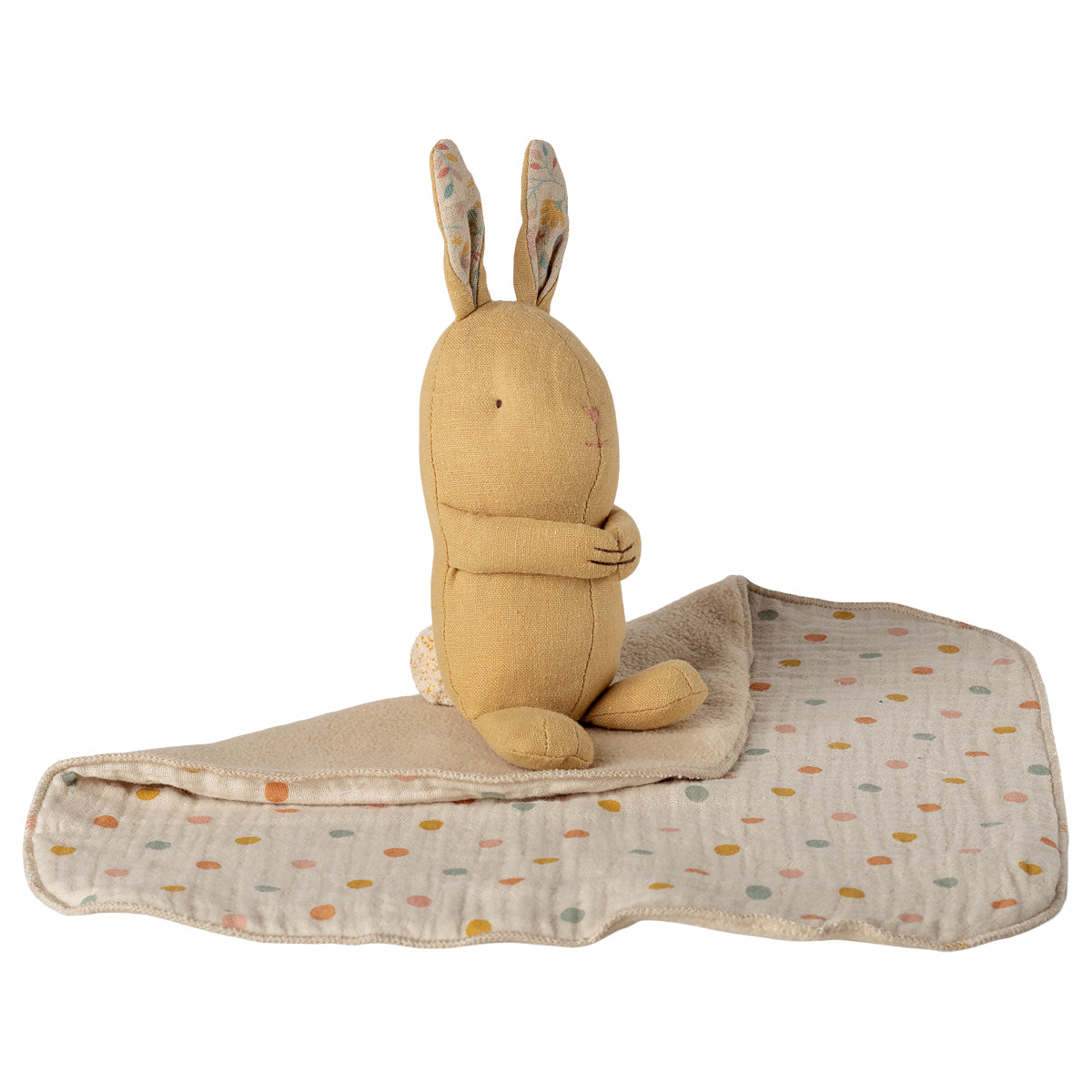 Maileg Stoffhase in Cremegelb sitzt auf Kuscheldecke, umgeschlagen dargestellt mit flauschiger Innenseite und Leinen-Außenseite mit bunten Punkten