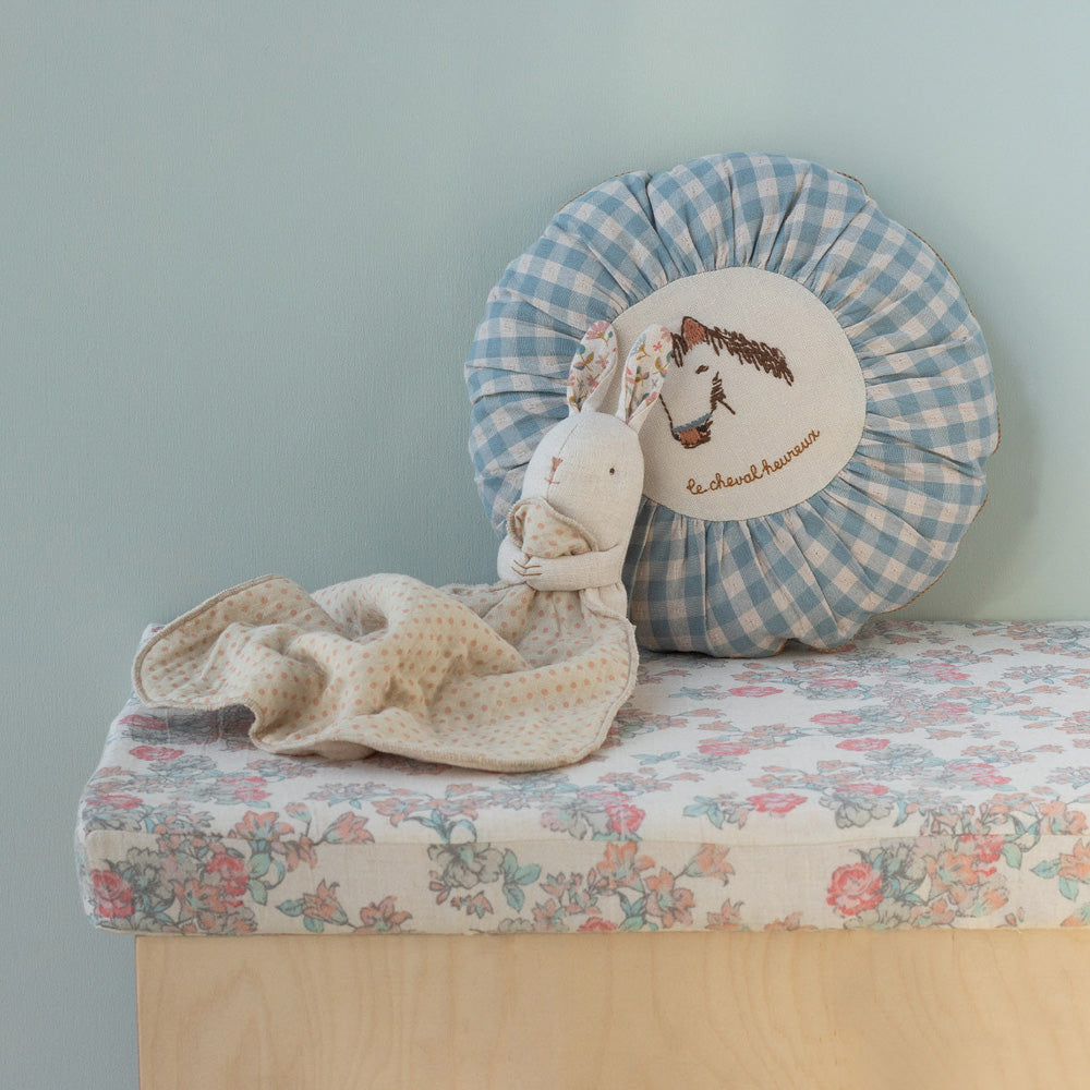 Maileg Stoffhase mit Kuscheldecke zugedeckt, angelehnt an einem Polster, gemütlich inszenierte Baby Geschenk Idee