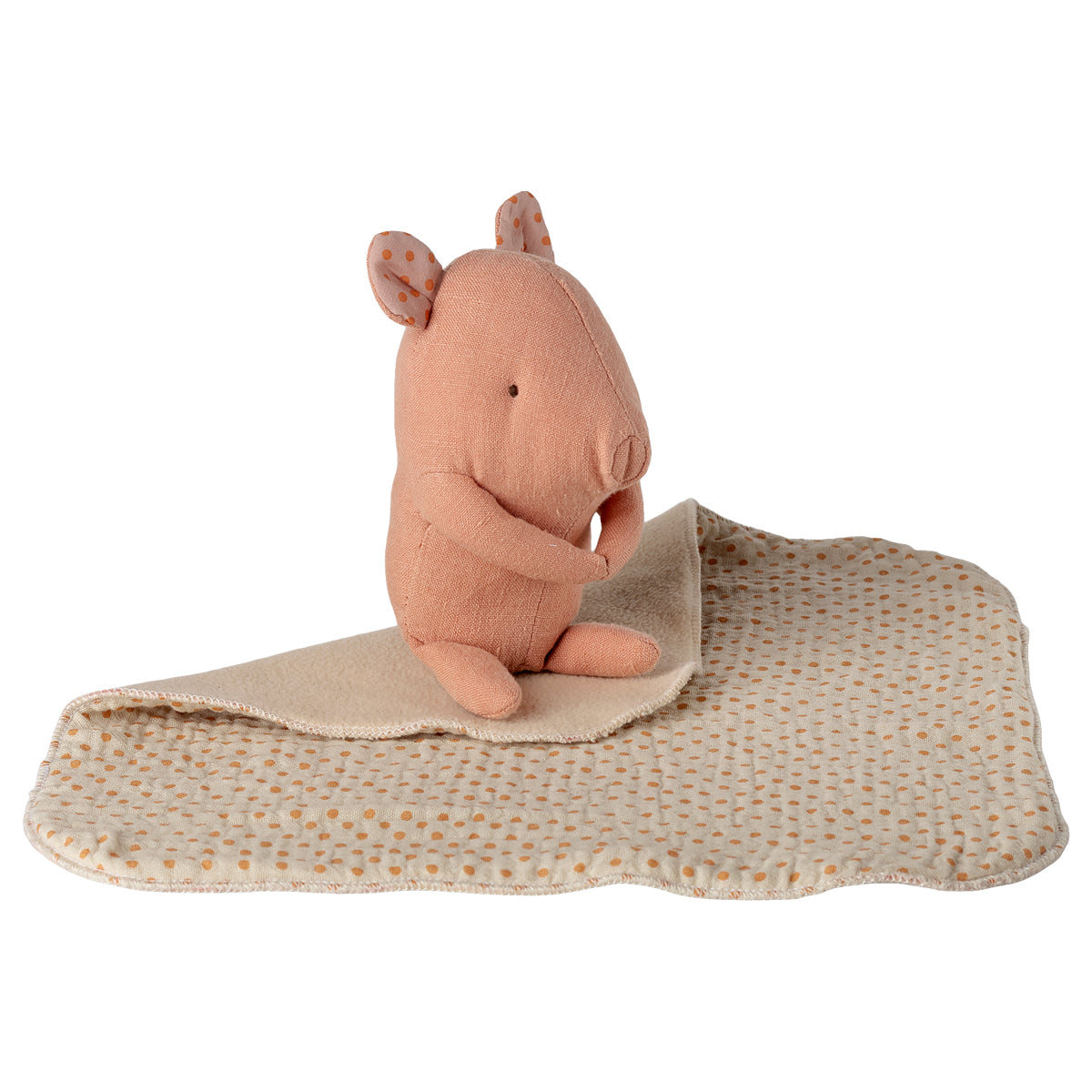 Maileg Stoffschwein in Rosa sitzt auf Kuscheldecke, umgeschlagen dargestellt mit flauschiger Innenseite und Leinen-Außenseite mit orangenen Punkten