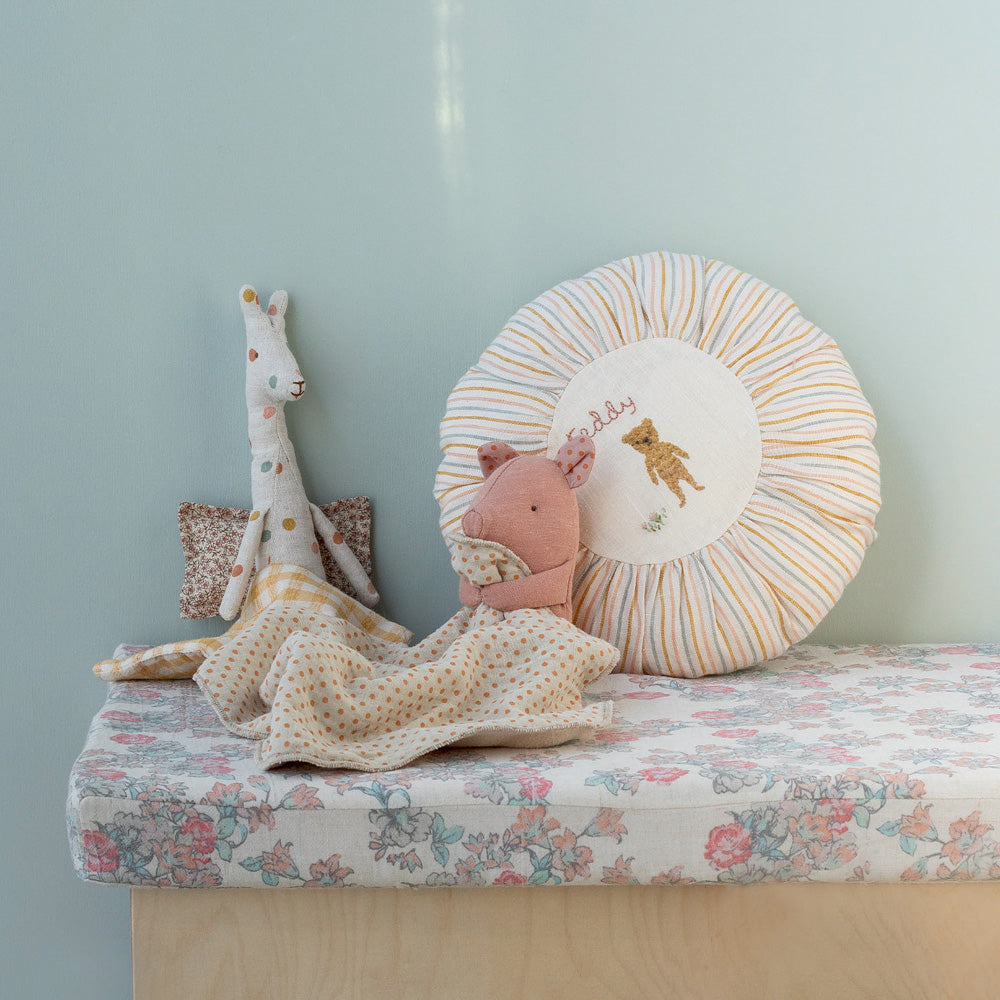Maileg Stoffschwein mit Kuscheldecke zugedeckt, an ein Kissen gelehnt und zusammen mit einem weiteren Stofftier, gemütlich inszeniert