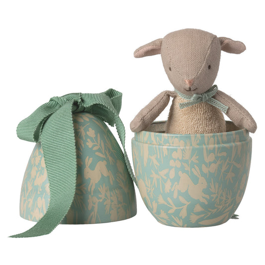 Geöffnetes Osterei in Dusty Minze mit kleinem Lamm, cremefarbener Strick-Overall und blaue Schleife als Detail