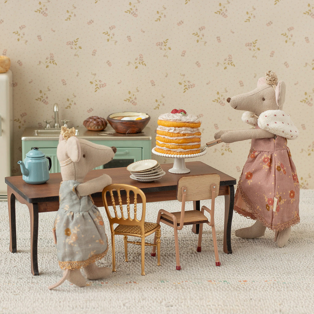 Maileg Kuchen auf Kuchenplatte auf Küchentisch, Mama Maus und Kind dekorieren den Geburtstagstisch, liebevoll inszenierte Feier-Szene