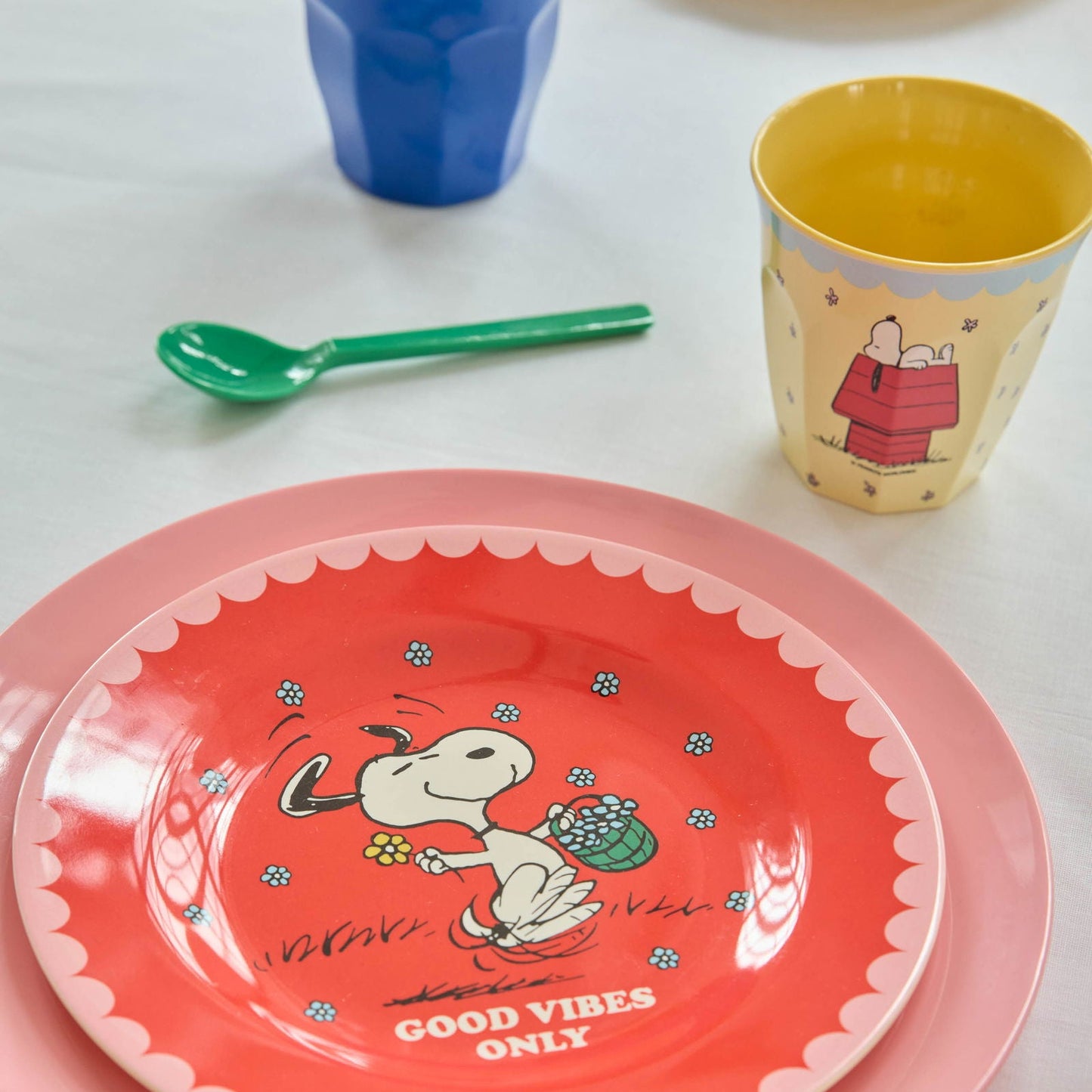 Roter Rice Kinderteller mit Snoopy im Peanuts-Design und dem Schriftzug „Good Vibes Only“, kombiniert mit einem creamfarbenen Snoopy-Melaminbecher von Rice, liebevoll arrangiert für eine fröhliche und harmonische Tischszene für Kinder
