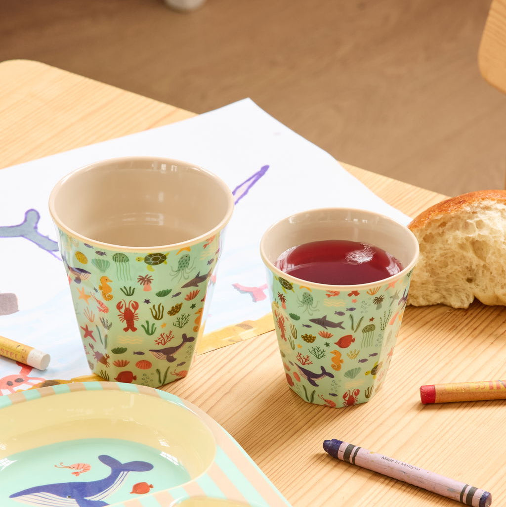 Moodbild mit zwei Melaminbechern von Rice in den Größen Small und Medium, blau mit Meerestier-Motiv, dekorativ auf einem Esstisch platziert
